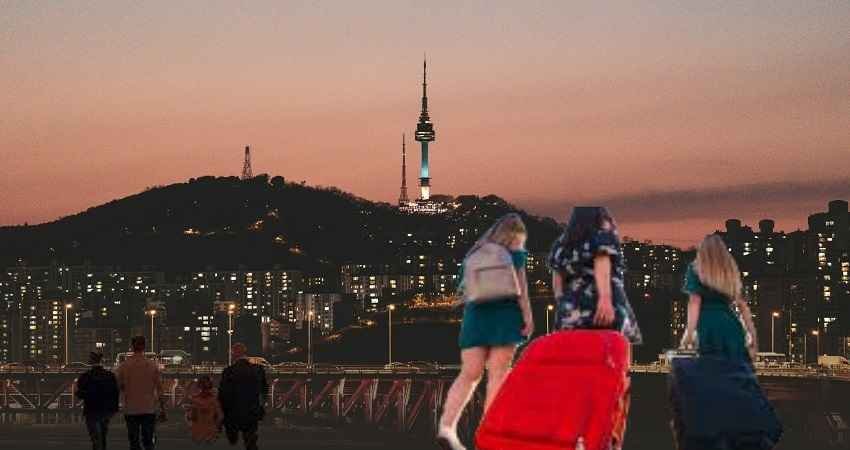 A group of travelers with their suitcases are walking in the direction of a city skyline lit up by the sun going down, which is a metaphor for the affordable journeys that have been made easy by the use of discount codes TTweakAirline by ​‍​‌‍​‍‌​‍​‌‍​‍‌TravelTweaks.